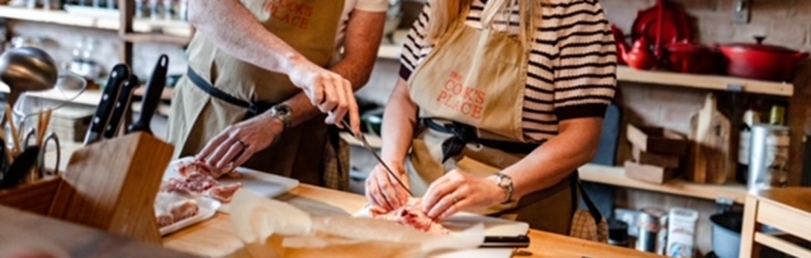 Two people preparing food in a cookery school