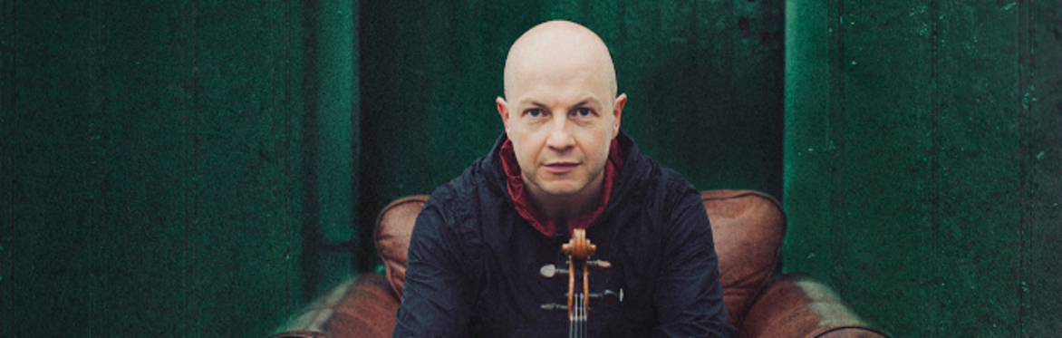 John McCusker face on view holding his fiddle