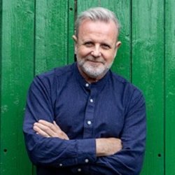 Michael Londra standing in front of large green door