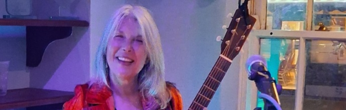 picture of the performer with her guitar