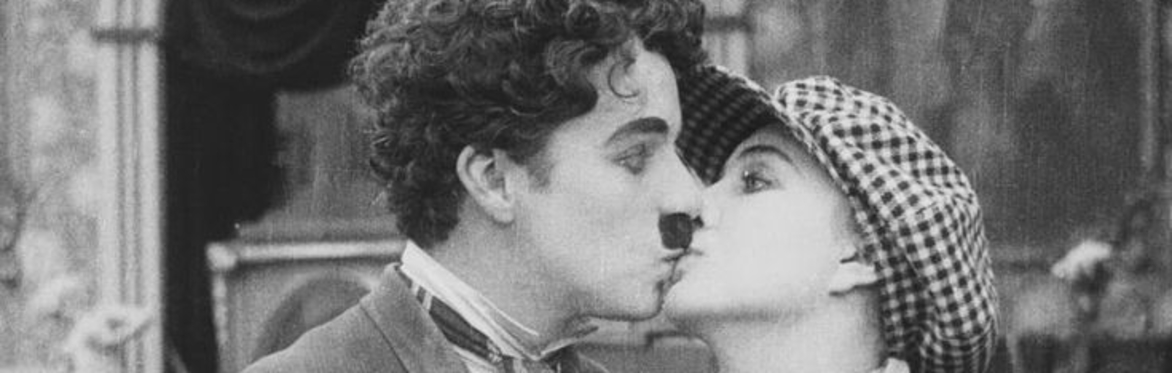 Charlie Chaplin receiving a surprise kiss.