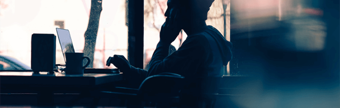 person with laptop in a cafe with a hot drink silhouette