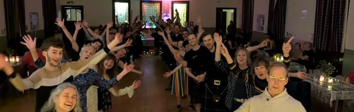 Ceilidh goers celebrate together in a church hall