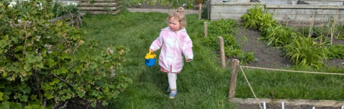 Young girl outside with a watering can