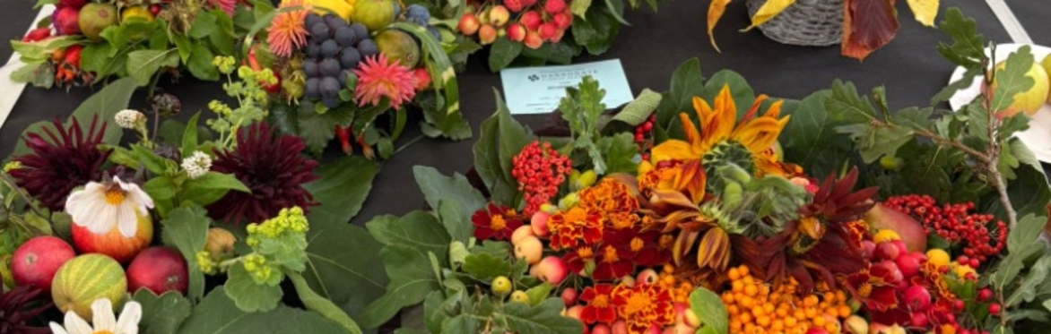 a basket of colourful flowers, berries and produce