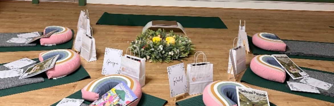 Bump and Chill space set up with 6 Yoga mats and blankets, around a floral display with yellow flowers.