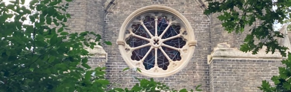 Image of Abney Park Chapel's rose window surrounded by trees