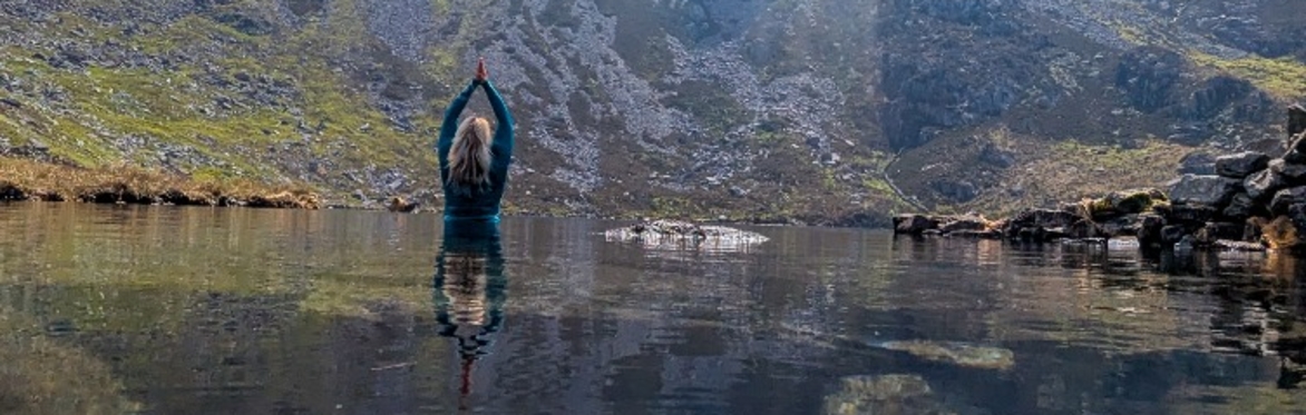 lady about to swim in a mountain lake on a sunny day