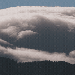 A flyover of the ocean with a cloudy sky above