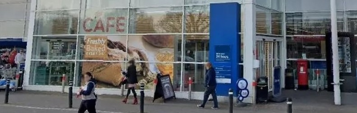 A photograph of the front entrance of a large modern supermarket