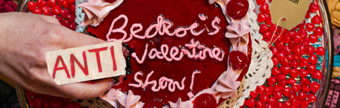 Cake with text that reads Bedroc valentine show and a piece of tape over a hand removing a piece of cake which reads anti