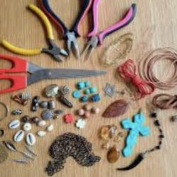 Image of hands making craft bracelets.