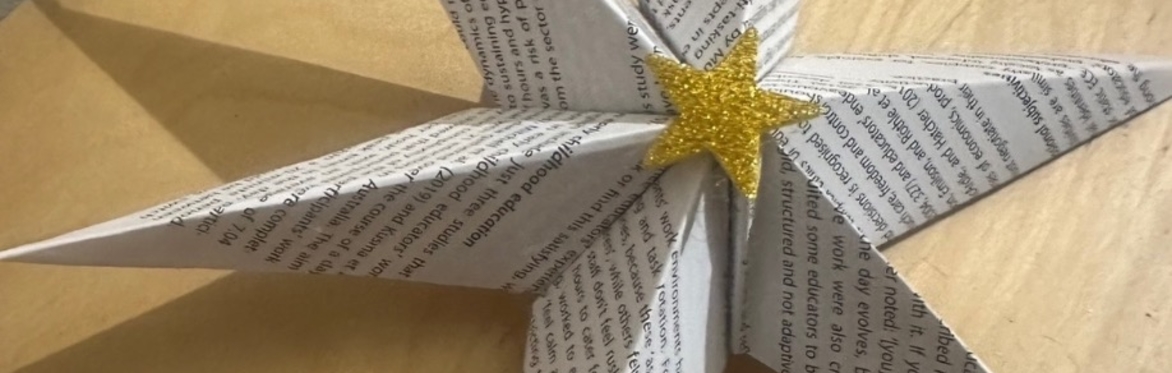 The image shows a Christmas themed decoration with gold baubles and stars against snow.
