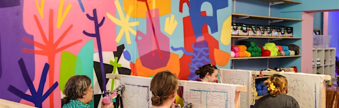 People Sitting Tufting Rugs In A Group (Banner)