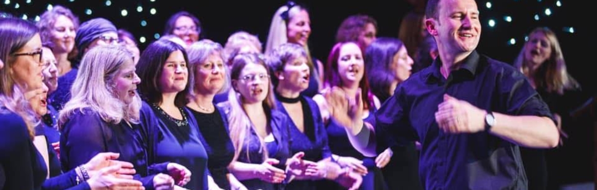 Choir members happily singing in an evening concert