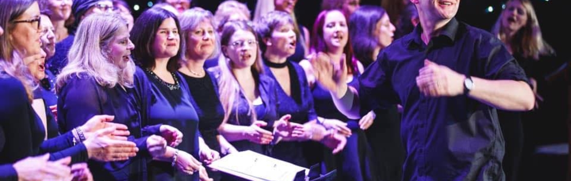 Choir members happily singing in an evening concert
