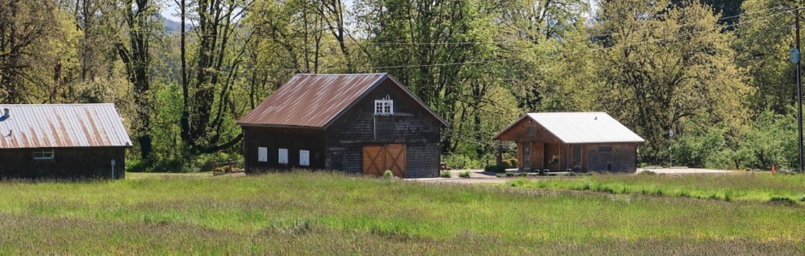 A barn in a grassy field.