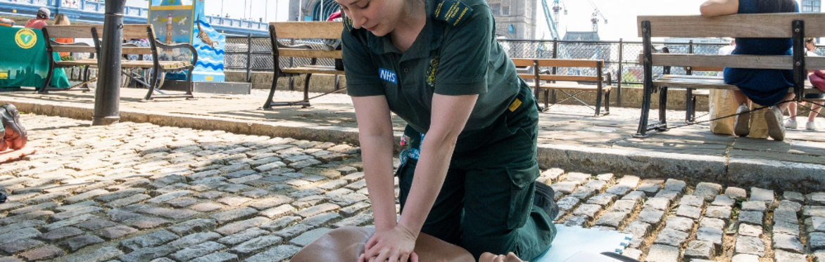 A photo of two people performing CPR and operating a defibrillator