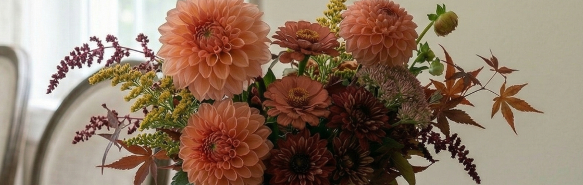 A floral arrangement with dahlias, zinnias, and autumn foliage
