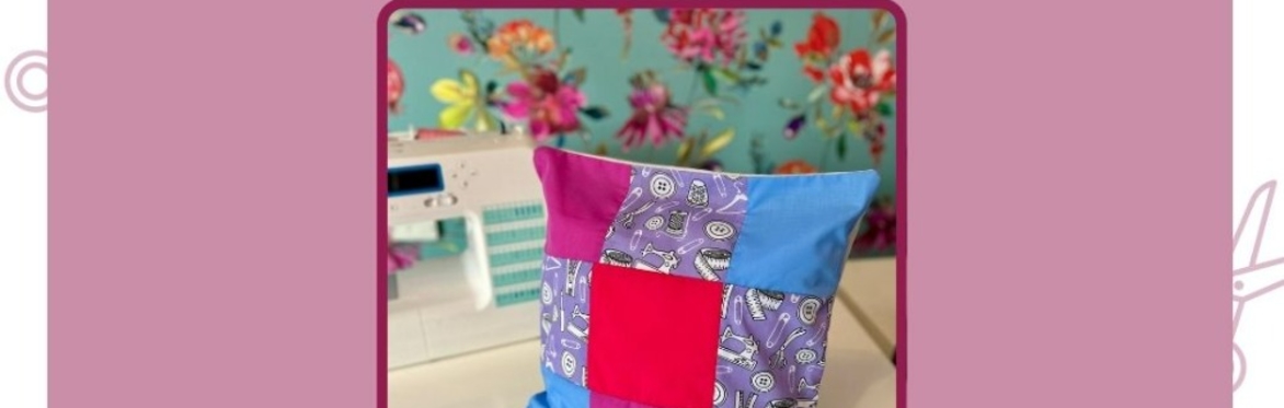 sewing machine with a patchwork cushion next to it.