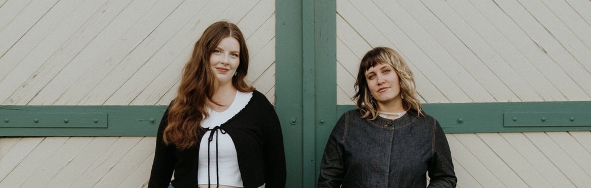 Two women in front of barn doors