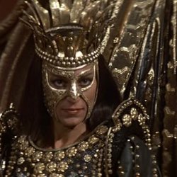 A queen in black and gold glowers at the camera