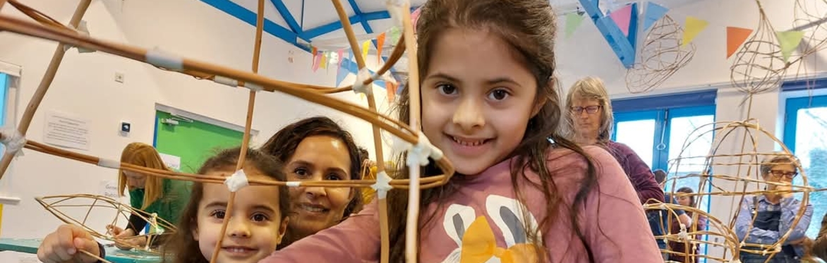 A smiling family show off their work in progress lantern