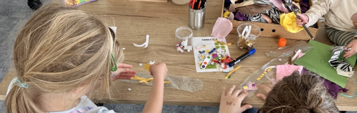 Children sitting at a table taking part in a craft activity.