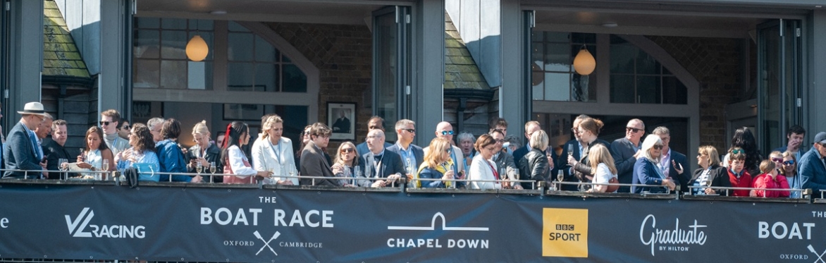Hospitality guests watching from the Thames Rowing Club balcony