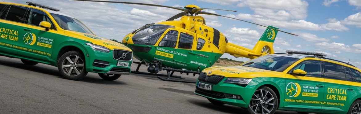 Yellow Toyota Supra parked in front of the Hampshire and Isle of Wight Air Ambulance helicopter