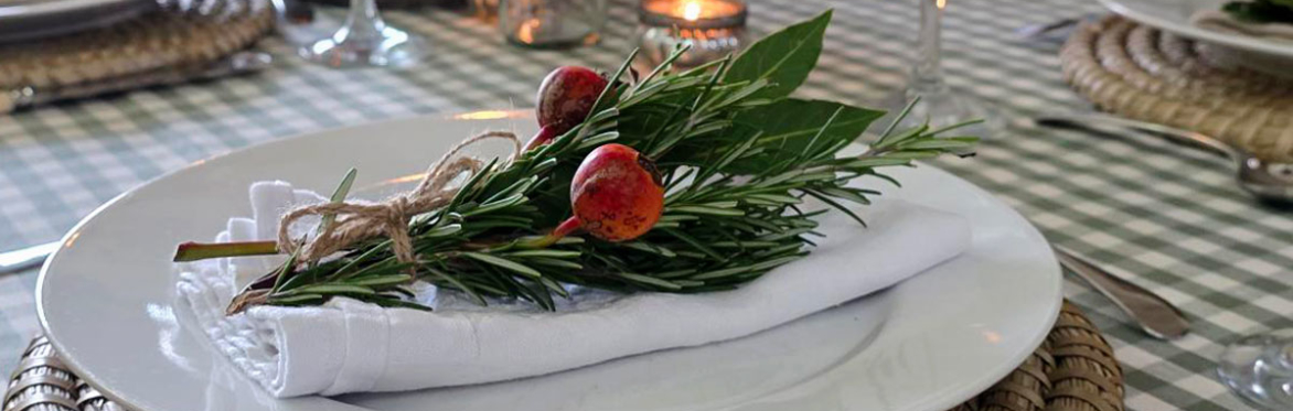 A beautifully styled table sharing natural foliage to decorate a place setting and napkin