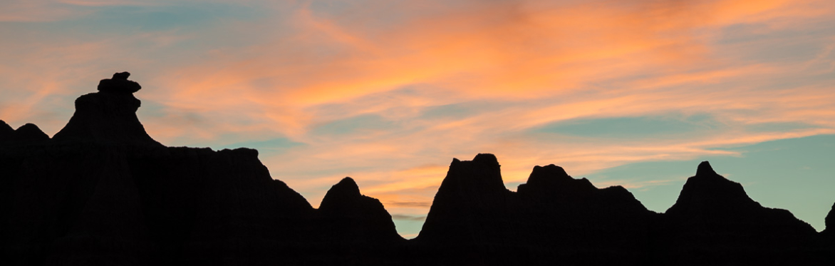 Badland formations set against the sunset