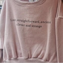 A pink jumper with the black text written on it: "Live, straightforward, ancient, clever and strange"