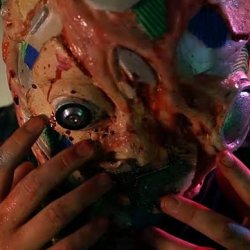 A distorted multi coloured alien seeming face