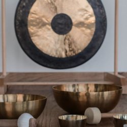 Gong with Himalayan singing bowls in the foreground.