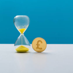 An egg timer with money next to it