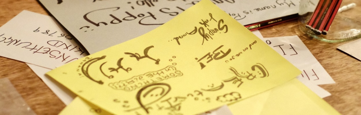 Examples of different typography and wording in brush lettering on sheets of paper