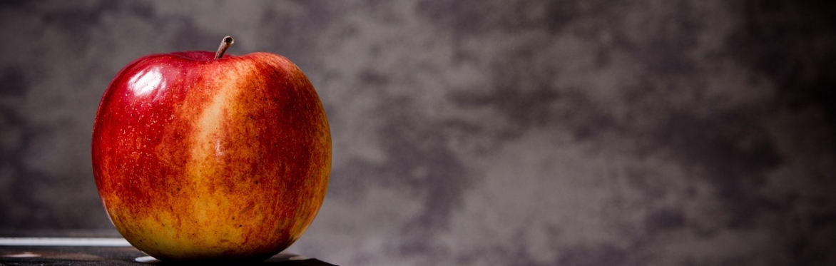 An apple sitting on a pile of books