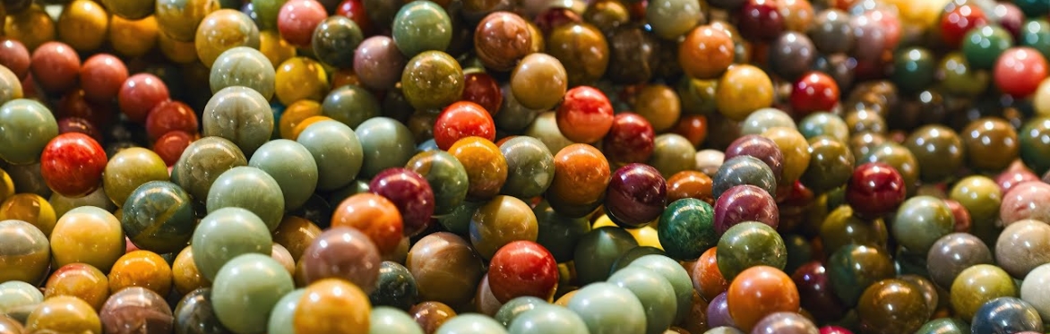 A variety of spherical gemstone beads on a string.