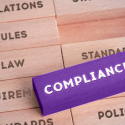 Compliance written on a purple block