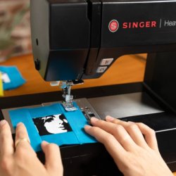 An image of a black hand drawn sewing machine on a green gradient background.