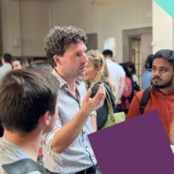 Students talking to Dr LIam Beiser McGrath at the Buzz event