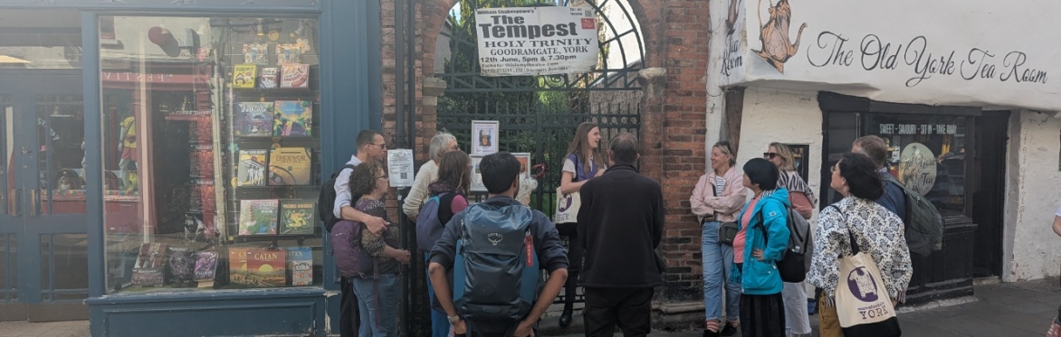 An image of a the Unconventional York Tour, with people listening to a guide as they talk about the history of Chocolate in the city.