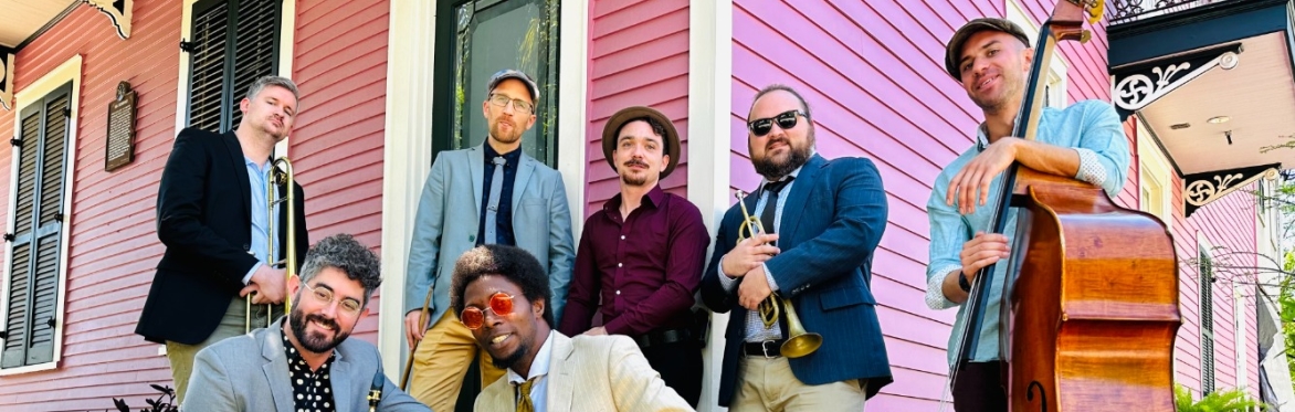 Sunny Side 7 piece jazz band in front of pink French Colonial style home.