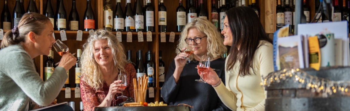 People smiling and drinking wine with each other