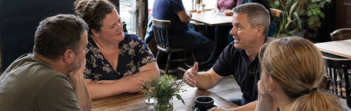 Men and women sat talking and listening in casual environment