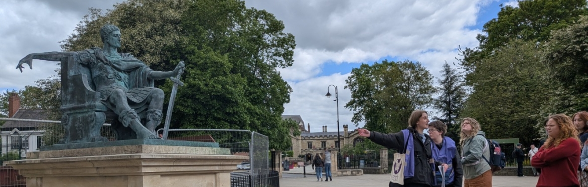 Woman pointing at statue, group of attendees