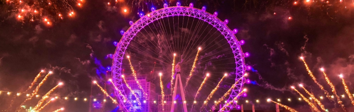 The London Eye from the north side of the Thames at night during the New Year's Eve fireworks display