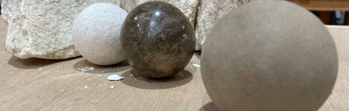A close up of a series of dorodango balls in various stages of progress