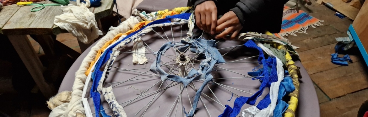 textiles are woven onto a bicycle wheel frame